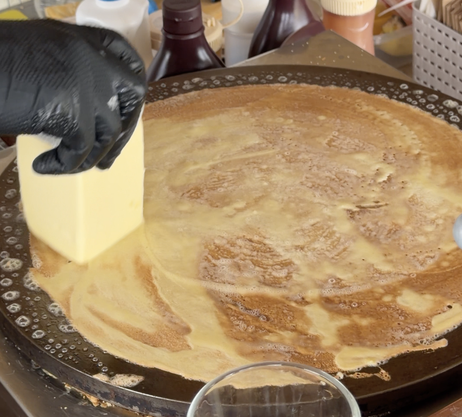 くれゑぷ屋で鉄板にバターをのせて焼くクレープの製造風景